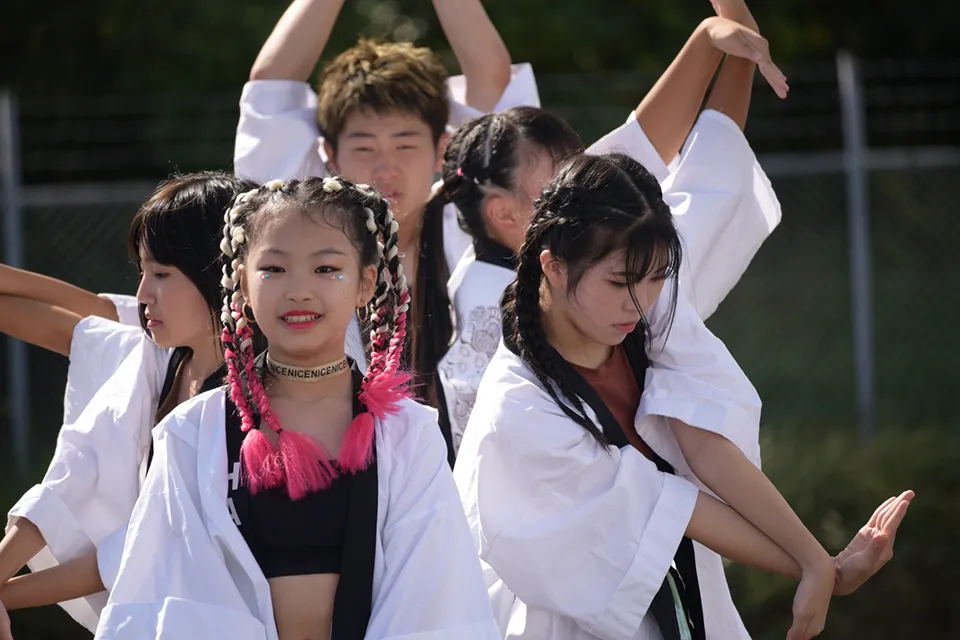 白い衣装でストリートダンスを踊る若者たち