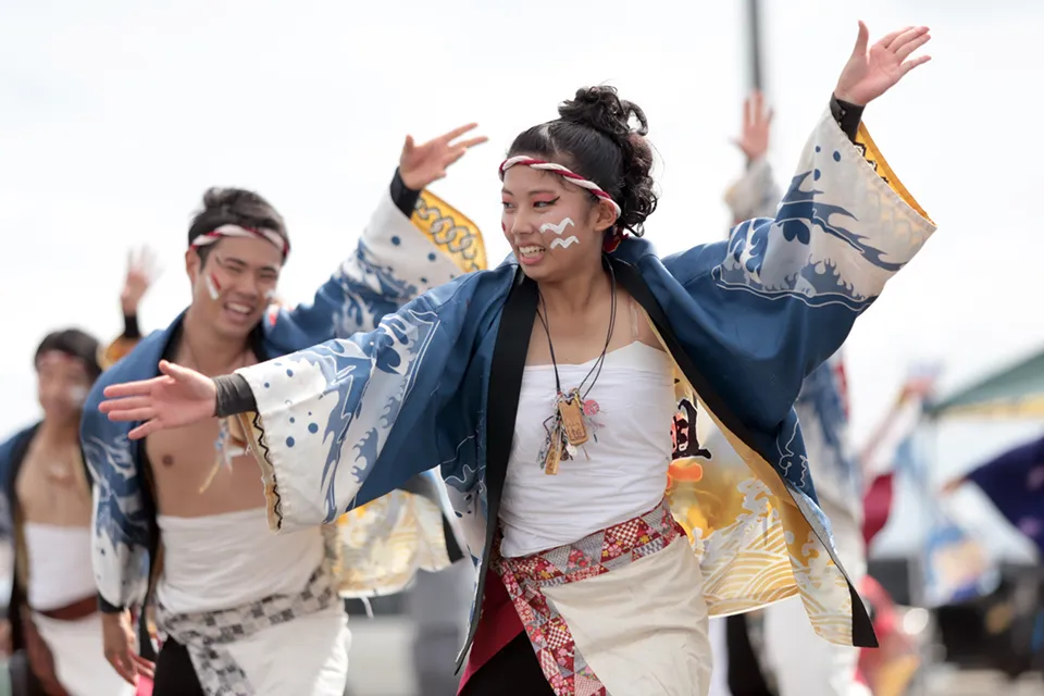 笑顔で踊る法被姿の男女ダンスグループ